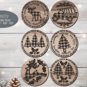 May include: Six round wooden coasters with a Christmas theme. Each coaster features a different design, including a moose, a truck with a Christmas tree, a reindeer, and various Christmas trees. The designs are all in black and white with a buffalo plaid pattern.