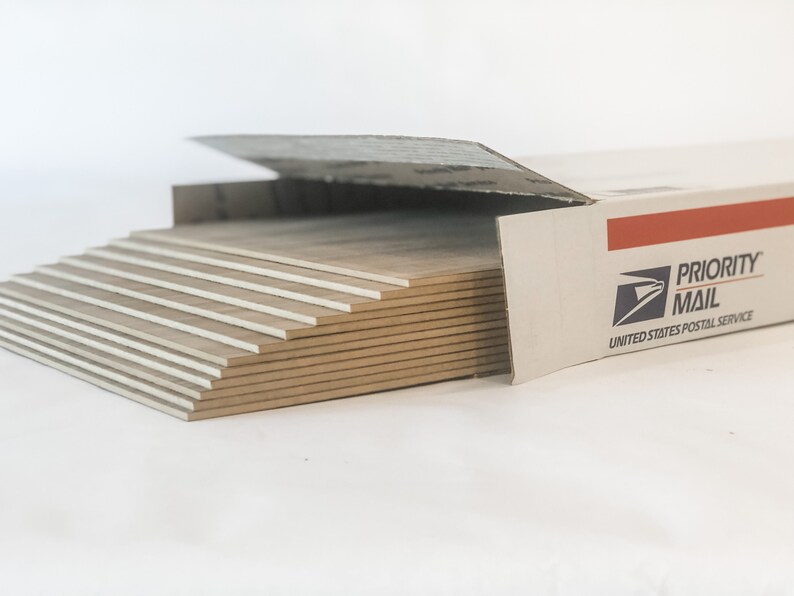 May include: A stack of beige ceramic tiles in a cardboard box labeled "PRIORITY MAIL" from the United States Postal Service.