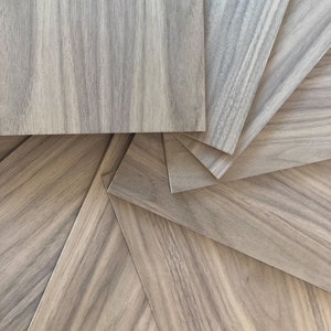May include: A close-up of several pieces of wood veneer arranged in a spiral pattern. The wood has a light brown color with darker brown streaks.