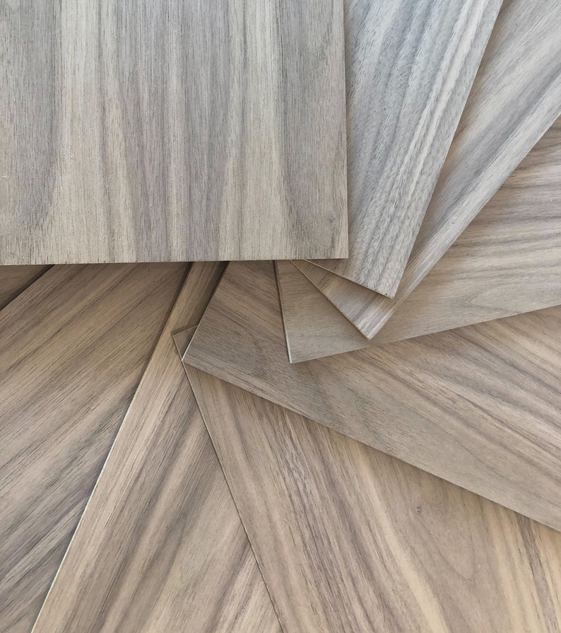 May include: A close-up of several pieces of wood veneer arranged in a spiral pattern. The wood has a light brown color with darker brown streaks.