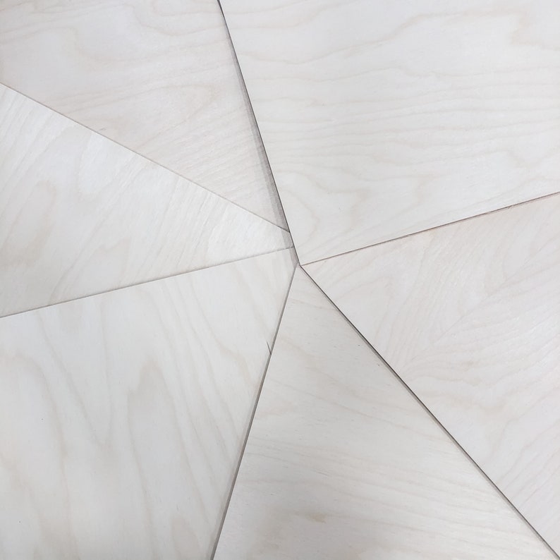 May include: A close-up of a white wood surface with a geometric pattern created by the way the wood panels are joined together.