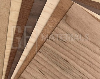 May include: A close-up of a variety of wood veneer sheets, including maple, walnut, and cherry. The sheets are arranged in a fan shape, with the grain of the wood visible.  GF Materials is printed on the bottom right corner of the image.