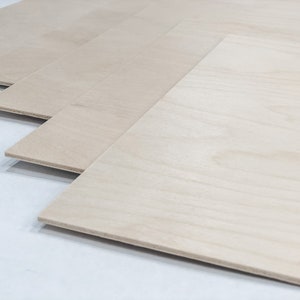 May include: Stack of four light brown plywood sheets, each with a slightly different grain pattern.