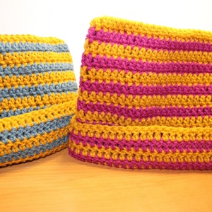 May include: Two crocheted striped bags, one in blue and yellow, the other in pink and yellow.