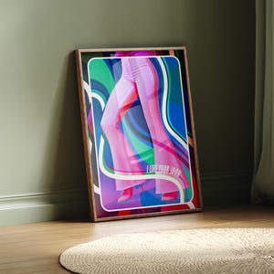 May include: A framed art print featuring a colorful illustration of a person's legs in pink flared pants. The artwork has a retro style with the text "I LOVE YOUR LOOK" in the bottom right corner. The print is leaning against a green wall.
