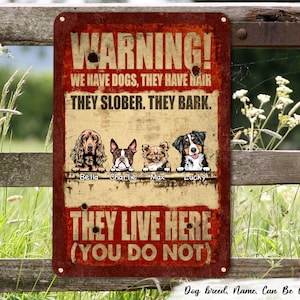 May include: A red and white warning sign with the text "WARNING! WE HAVE DOGS, THEY HAVE HAIR. THEY SLOBBER. THEY BARK. THEY LIVE HERE (YOU DO NOT)". The sign features four cartoon dogs with the names Bella, Charlie, Max, and Lucky.