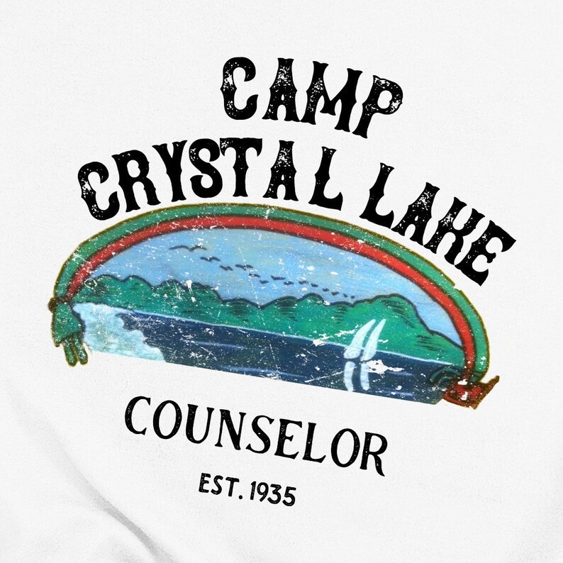 Pu&ograve; includere: Un design grafico in stile vintage con il testo "Camp Crystal Lake Counselor Est. 1935". Il design presenta un arcobaleno sopra una scena di lago con montagne e una barca a vela.