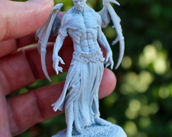 Puede incluir: Una miniatura gris impresa en 3D de una figura humanoide alada con un torso musculoso detallado y una falda fluida. La figura está de pie sobre una base circular con diseños intrincados.