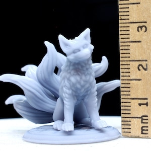 May include: A light grey, unpainted resin figurine of a nine-tailed fox sitting on a circular base. A wooden ruler is positioned vertically next to the figure, showing a height of approximately 3.2 cm from the base to the top of the ears.