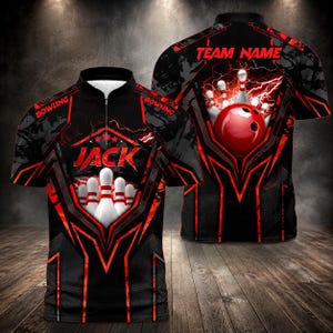 May include: A black and red short-sleeve polo shirt with a quarter-zip neckline. The front features the text JACK above a bowling pin graphic, while the back displays a red bowling ball, pins, and the text TEAM NAME with lightning accents.