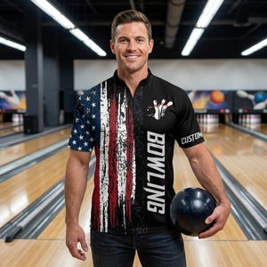 May include: Bowling shirt featuring a distressed American flag design on the left side and a black panel with bowling pins and the word "BOWLING" on the right. The shirt has a custom sleeve detail and is worn with blue jeans. A bowling ball is held.
