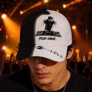 May include: A black and white baseball cap featuring a DJ graphic. The cap has a split design, with a black panel on the left and a white panel on the right. The white panel displays a DJ graphic, the text "YOUR NAME", and a sound wave design.