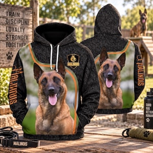 Puede incluir: Una sudadera con capucha jaspeada negra con un gran estampado fotográfico de un perro pastor belga malinois en la parte delantera y trasera. El diseño incluye un emblema en forma de escudo con el texto Malinois y la palabra Malinois impresa en naranja.