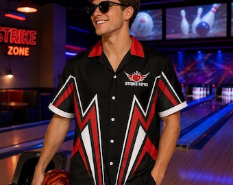 May include: A black short-sleeve button-down shirt featuring a red and white geometric lightning bolt pattern, a red collar, and a logo on the chest that reads STRIKE KING with a graphic of a bowling ball and wings.