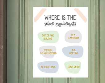 Può includere: Un cartello bianco su una porta verde recita "WHERE IS THE school psychologist?" con le opzioni: "Out of the building", "In a classroom", "Testing - Do not disturb", "In a meeting", "Be right back" e "Come on in".