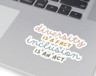 May include: A sticker with the text "diversity is a fact, inclusion is an act" in a colorful, handwritten font on a silver laptop.