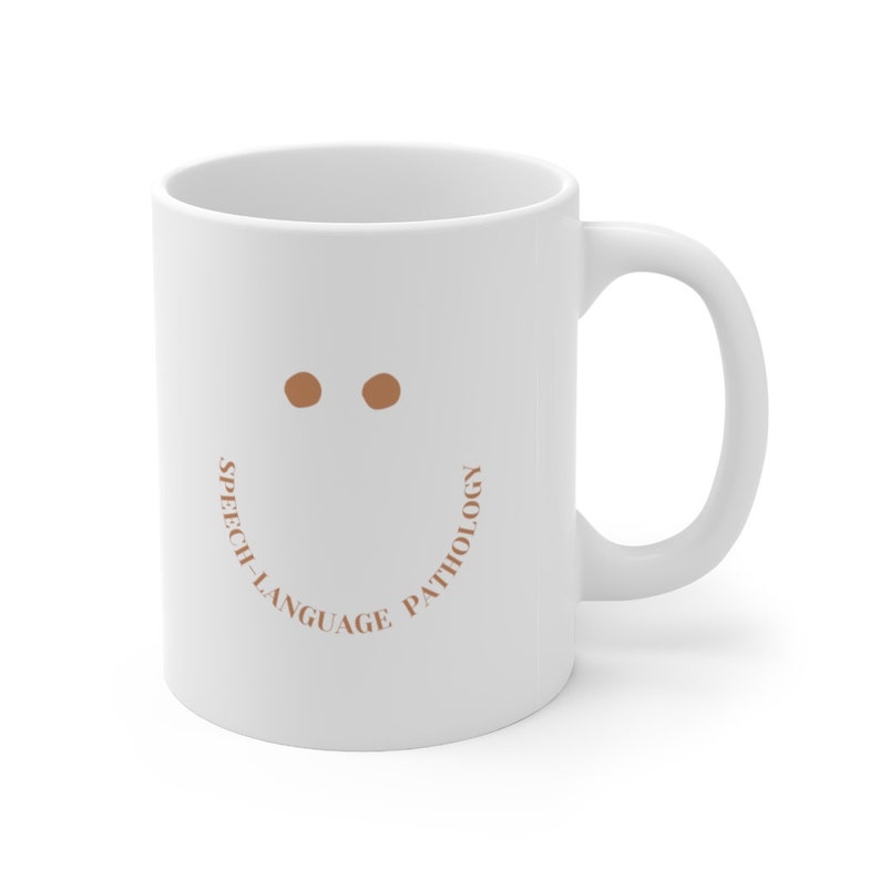 May include: White ceramic coffee mug with a brown smiley face and the text "Speech-Language Pathology" around the bottom of the mug.