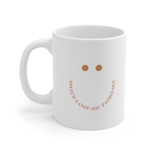 May include: White ceramic coffee mug with a brown smiley face and the text "Speech-Language Pathology" around the bottom of the mug.