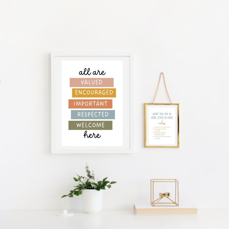 May include: A framed print with the text "all are valued encouraged important respected welcome here" in a colorful block design. A second framed print with the text "What you say in here stays in here unless..." and a list of rules is also visible.
