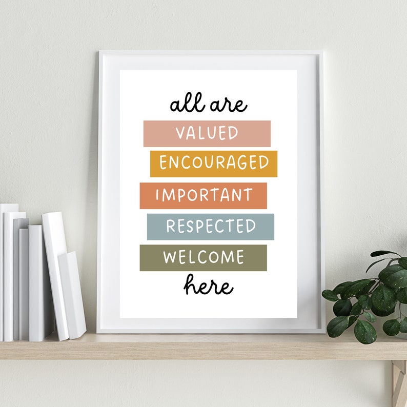 May include: A white framed print with the text "all are valued encouraged important respected welcome here" in black lettering. The words are stacked vertically and each word is on a different colored rectangle. The colors are pink, orange, yellow, blue, and green.