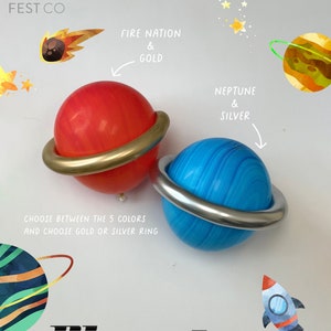 May include: Two large inflatable planet balloons with rings. The red balloon has a gold ring and the blue balloon has a silver ring. The text "Fire Nation & Gold" is above the red balloon and the text "Neptune & Silver" is above the blue balloon. The text "Choose between the 5 colors and choose gold or silver ring" is below the balloons. The text "Planet" is at the bottom of the image.