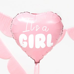 May include: Pink heart-shaped foil balloon with the text "It's a Girl" in white lettering.