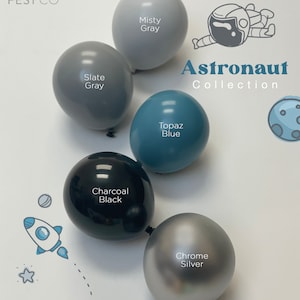 May include: A set of 5 balloons in various colors, including misty gray, slate gray, topaz blue, charcoal black, and chrome silver. The balloons are arranged in a semi-circle and have the text "Astronaut Collection" printed on them.