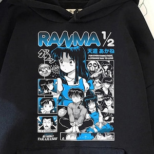 Puede incluir: Sudadera con capucha negra con un estampado gráfico azul "RAMMA 1/2", texto japonés e ilustraciones de personajes. Tiene un bolsillo delantero y una capucha.
