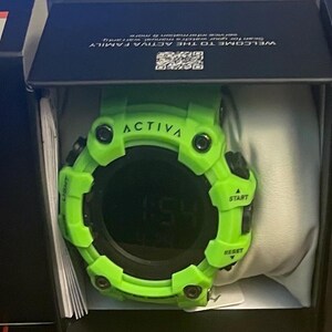 May include: A bright lime green digital watch with a round face and black accents, featuring the word ACTIVA printed on the bezel. The watch is housed inside a black box with the brand name ACTIVA printed in white on the front and side panels.