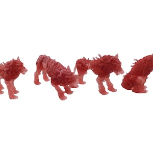 May include: Four translucent red wolf figurines in various poses. The wolves are in a walking, running, and sitting positions. The figurines have a skeletal appearance, with visible rib cages and spine details. The background is plain white.