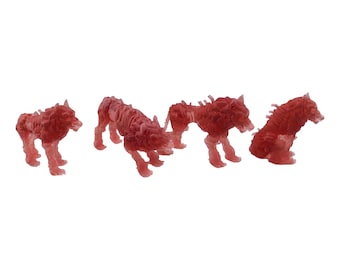 May include: Four small, translucent red wolf figurines arranged in a row. Each figure displays detailed, textured fur and muscular anatomy, captured in various standing and crouching poses, showcasing a semi-transparent, glossy finish.