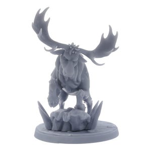 May include: A grey figurine of a moose with large antlers, standing on a small, round base with stylized grass and a rocky texture. The moose has a detailed, textured surface.