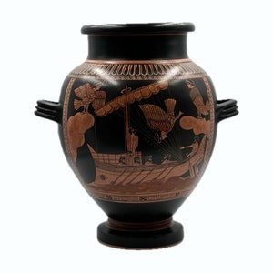 Może przedstawiać: Czarna i czerwona grecka amfora z dwoma uchwytami i ozdobnym wzorem przedstawiającym statek z ptakami i postaciami.