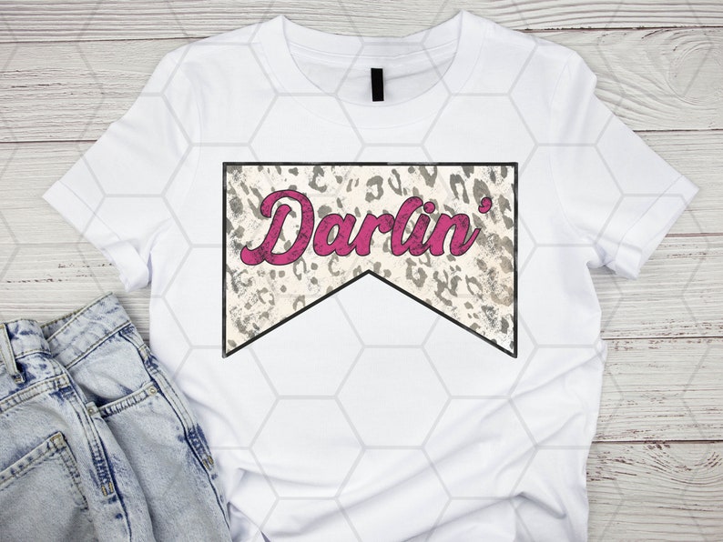 Op de afbeelding: Wit T-shirt met een grijze en witte luipaardprintbanner met de tekst "Darlin'" in roze.