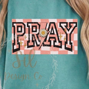 May include: A pink and white checkered background with the word "PRAY" in black block letters. A yellow lightning bolt with a smiley face daisy is in the centre of the word.