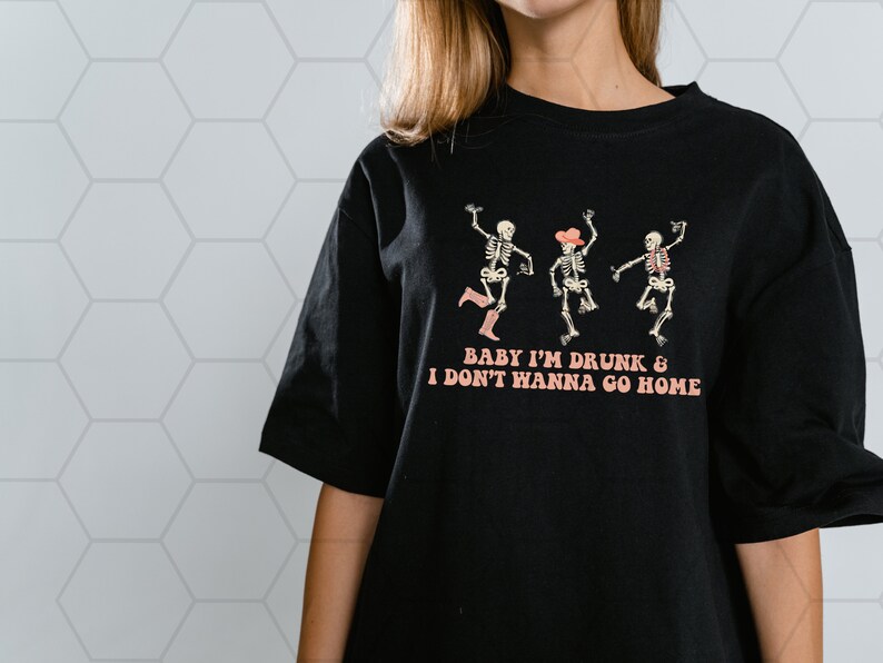 May include: Black t-shirt with a graphic of three skeletons dancing. The text "Baby I'm Drunk & I Don't Wanna Go Home" is printed below the skeletons.