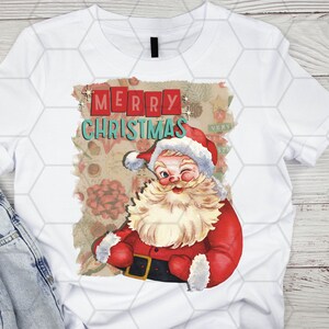 May include: White t-shirt with a vintage-style Christmas graphic featuring Santa Claus winking and the text "Merry Christmas".