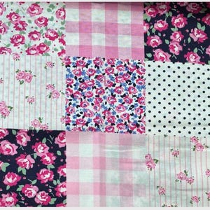 May include: A patchwork fabric with a variety of patterns. The design includes squares of pink gingham, white polka dots, pink roses on navy, and floral prints with pink and blue flowers. The overall theme is a vintage, floral design.