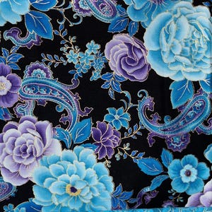 May include: Close-up of a fabric with a floral pattern. The design features large blue and purple flowers, paisley shapes, and gold accents on a black background. The flowers include roses and other detailed blooms.