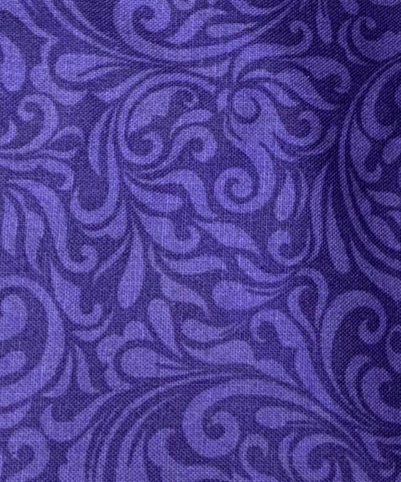 May include: Close-up of a fabric with a repeating pattern of swirling, stylized floral designs in shades of purple. The fabric has a textured appearance, with a subtle weave visible throughout the design. The overall effect is elegant and decorative.