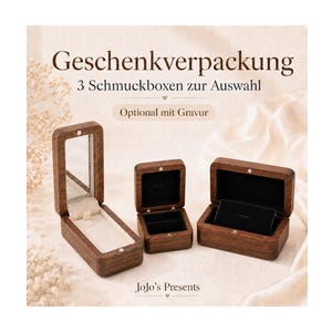 Könnte beinhalten: Drei dunkelbraune Schmuckkästchen aus Holz mit Klappdeckeln. Das linke Kästchen hat einen Innenspiegel und weißes Futter. Die mittleren und rechten Kästchen haben schwarze Samteinlagen. Text: Geschenkverpackung, 3 Schmuckboxen zur Auswahl, Optional mit Gravur, JoJo's Presents.
