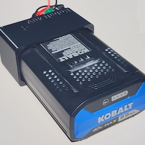 May include: A black and blue Kobalt 40V MAX 2.0Ah battery pack. The battery has a blue accent and the Kobalt logo is prominently displayed. The battery pack has a series of small holes and a power indicator. The text "Kobalt 40V" is visible.