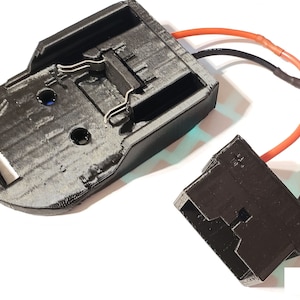 May include: A black plastic battery holder with two metal clips and a black plastic connector with red and black wires attached.