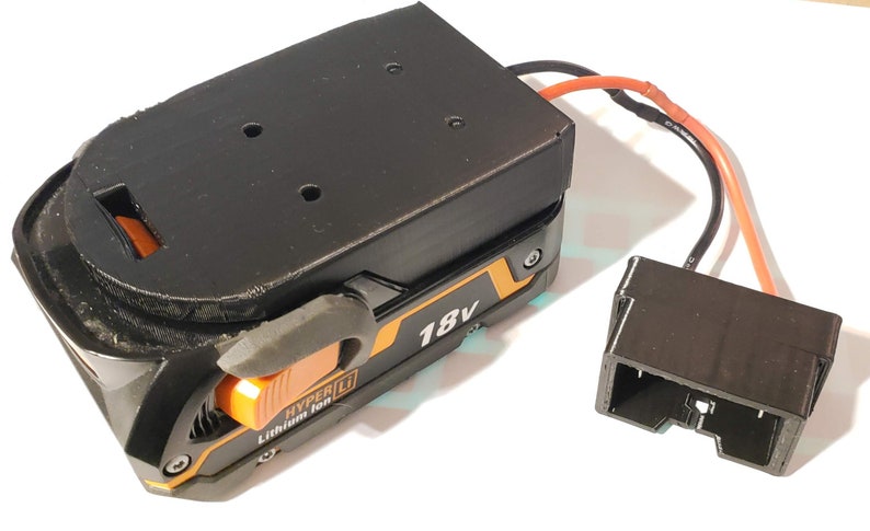 May include: A black and orange 18V battery pack with a black connector and a wire. The battery pack has a label that says "HYPER LI Lithium Ion".