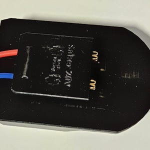 K&ouml;nnte beinhalten: Schwarzes elektrisches Bauteil mit zwei Dr&auml;hten, einem roten und einem blauen, die daran befestigt sind. Das Bauteil tr&auml;gt ein Etikett mit der Aufschrift "AUTOMATIC SWITCH".