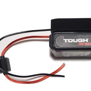 May include: A black and gray Tough 20V Max Lithium battery with red and black wires. The battery has the word "TOUGH" printed on it. The wires are connected to a black fuse holder with a green indicator light.