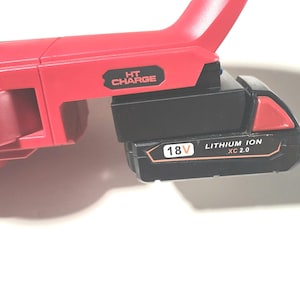 May include: A red power tool with a black 18V Lithium Ion XC 2.0 battery attached. The tool has the text "HT CHARGE" printed on the side. The battery is black with red accents and the text "18V" and "LITHIUM ION XC 2.0".