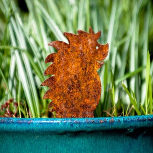 May include: A rusty metal hedgehog garden decoration sits in a blue planter filled with green grass.