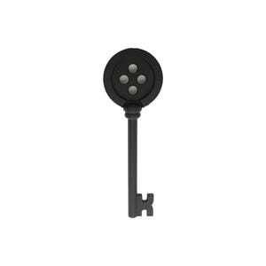May include: A black metal key with a round head featuring four holes. The key has a decorative design and a unique shape.
