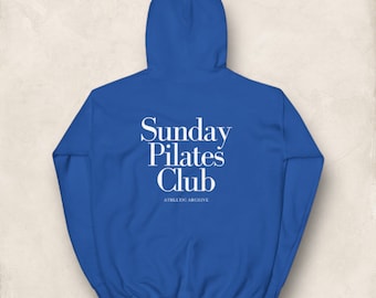 May include: Royal blue hooded sweatshirt with the text "Sunday Pilates Club" and "Athletic Archive" in white.
